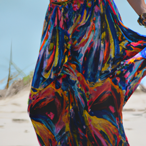 אישה לובשת שמלת מקסי שוטפת וצבעונית על חוף שטוף שמש, מדגישה את הרבגוניות של השמלה.